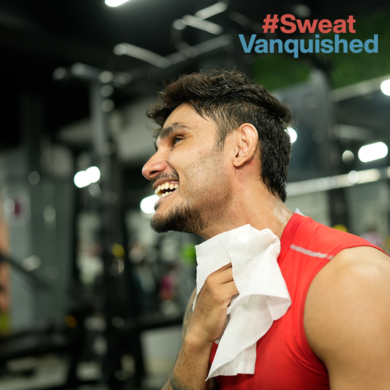 A man wiping his face with a towel after a workout