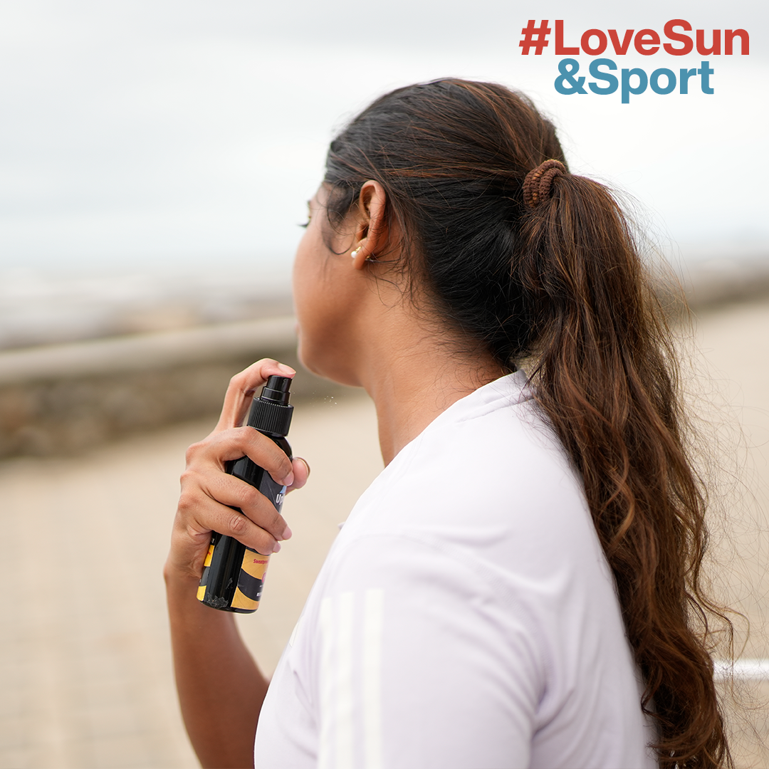 a woman holding a  sunscreen spray