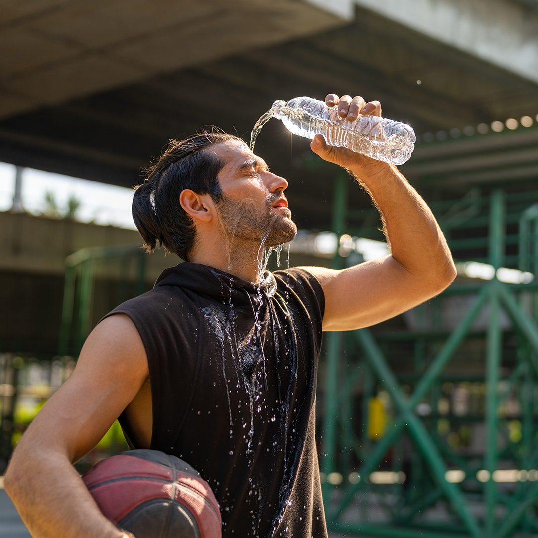 a man cleaning his face with water bottle